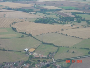 The view from the village centre towards the Grange and Abbey Farm hidden amongst the trees, near centre, with Northampton Road bottom right and New Row bottom centre.
